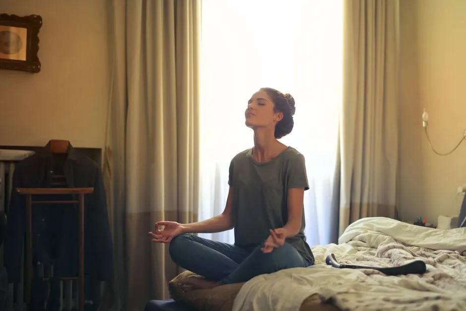 Woman meditating quietly in a calm bedroom